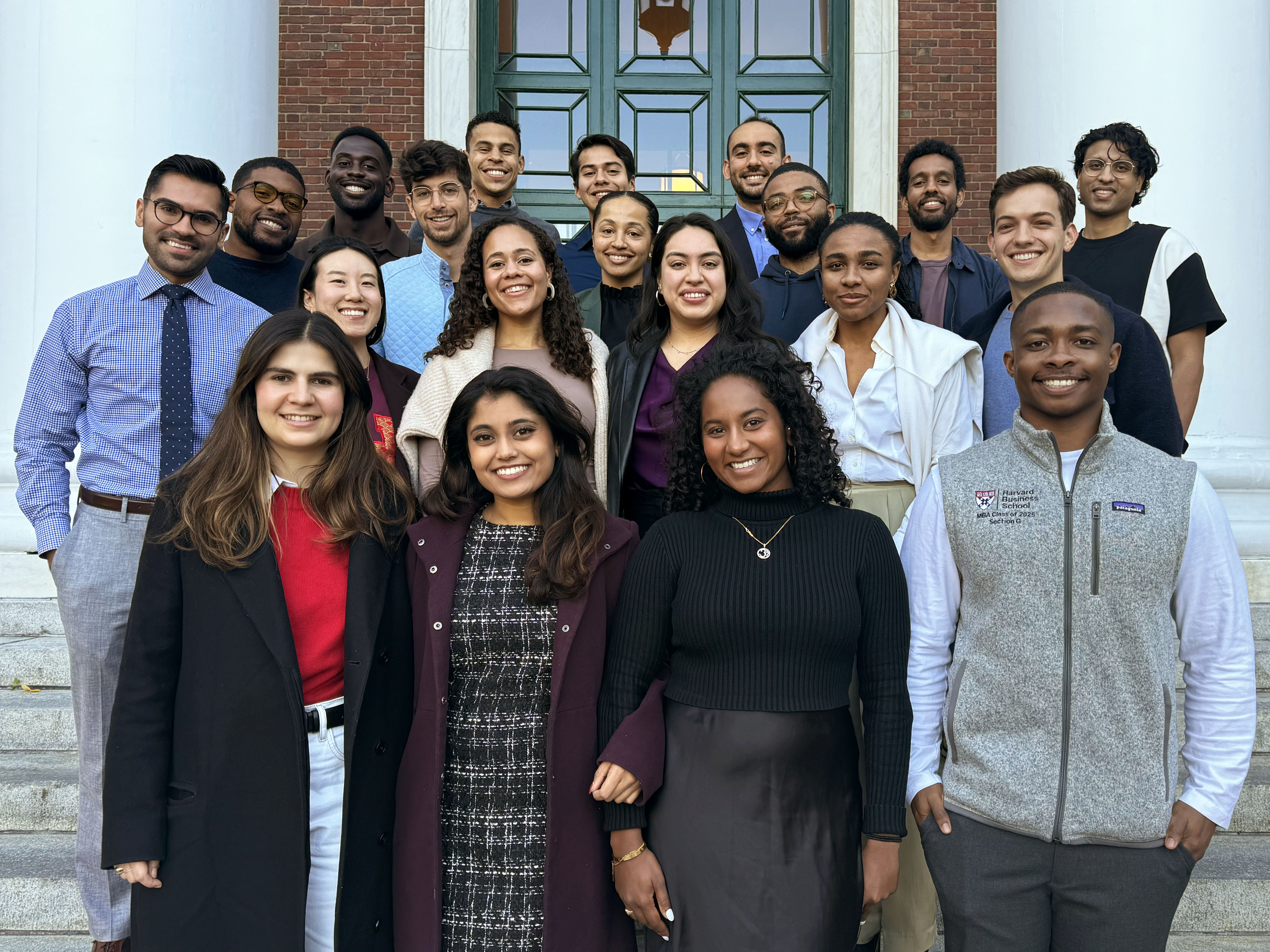 RISE Fellows from the classses of 2025 and 2026, standing on the Baker Library stepsl